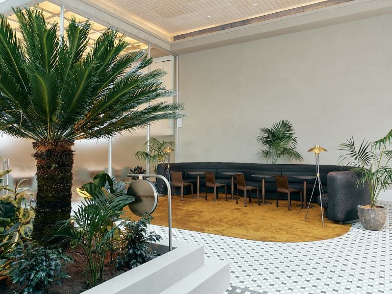 Novotel St Kilda. The garden atrium lounge, planted with palms, with banquette seating.
