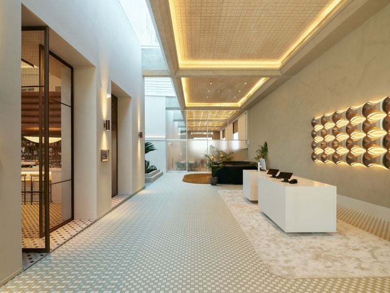 Novotel St Kilda. The reception desk in the long, top-lit lobby.